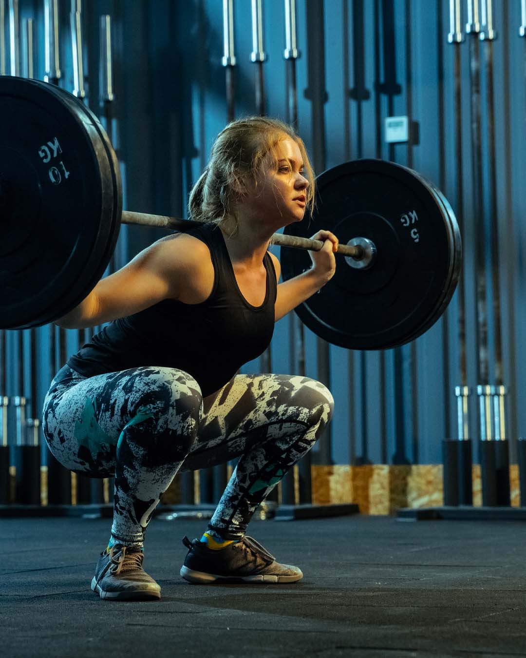 female athlete showing a deep squat in the barbell back squat for more power